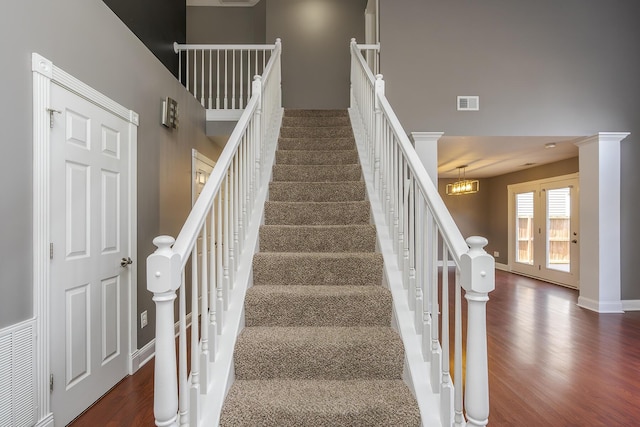 staircase featuring visible vents, baseboards, and wood finished floors