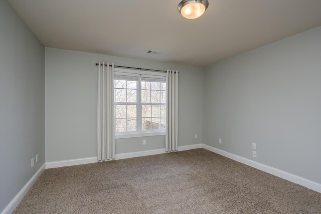 empty room featuring visible vents, carpet floors, and baseboards