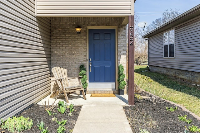 view of exterior entry with brick siding