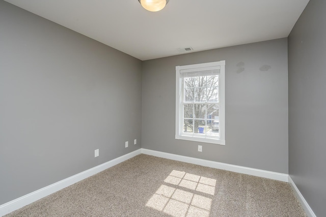 carpeted empty room featuring baseboards and visible vents