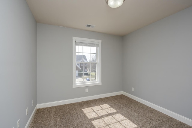 empty room with visible vents, baseboards, and carpet flooring