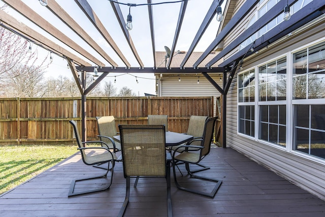 wooden terrace with outdoor dining area, fence, and a pergola