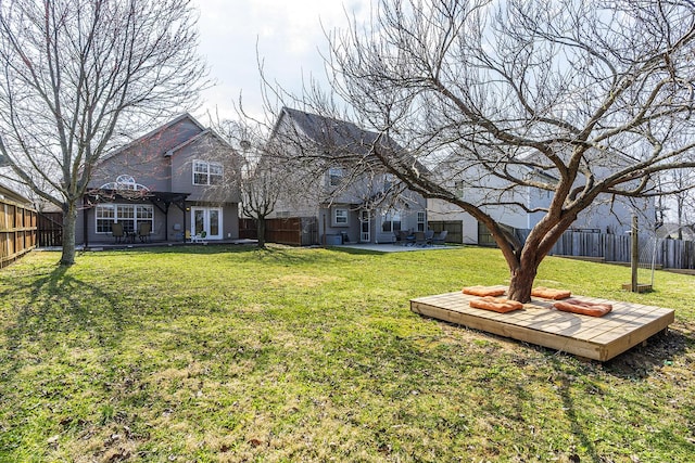 exterior space with a yard, a wooden deck, a fenced backyard, and a patio area