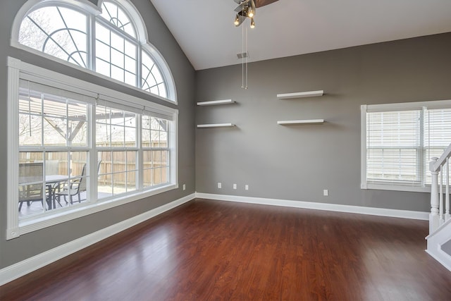 unfurnished room with dark wood finished floors, high vaulted ceiling, baseboards, and ceiling fan