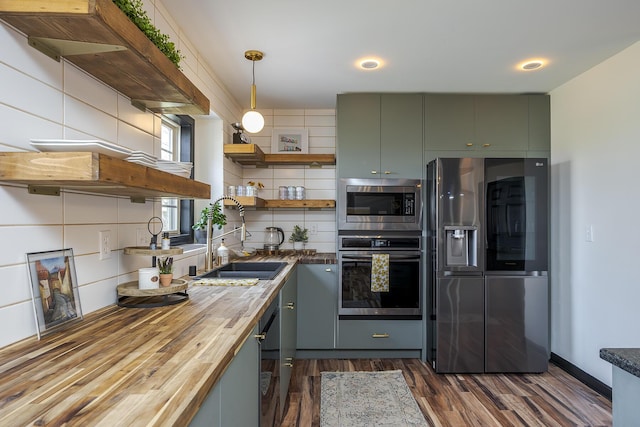 kitchen featuring dark wood-type flooring, butcher block countertops, open shelves, tasteful backsplash, and stainless steel appliances