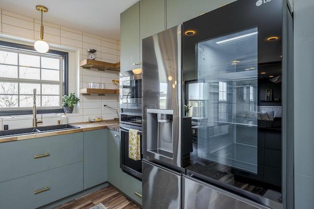 kitchen featuring stainless steel microwave, backsplash, a sink, wood counters, and open shelves