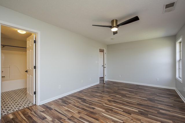 unfurnished bedroom featuring visible vents, ceiling fan, baseboards, dark wood-style floors, and a textured ceiling