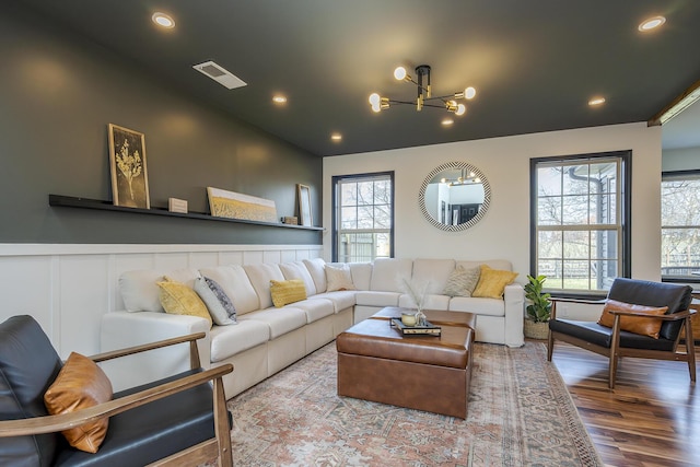 living room with visible vents, a wainscoted wall, recessed lighting, an inviting chandelier, and wood finished floors