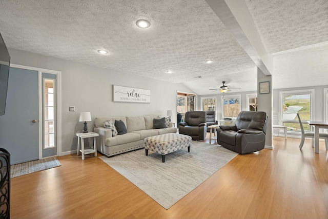 living room featuring baseboards, light wood finished floors, recessed lighting, ceiling fan, and a textured ceiling