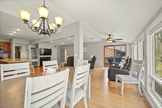 dining room with ceiling fan with notable chandelier, recessed lighting, and light wood-style floors