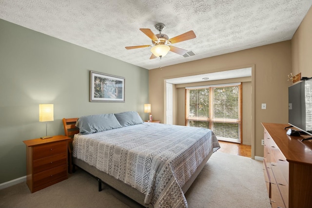 bedroom featuring access to outside, a textured ceiling, baseboards, light colored carpet, and ceiling fan