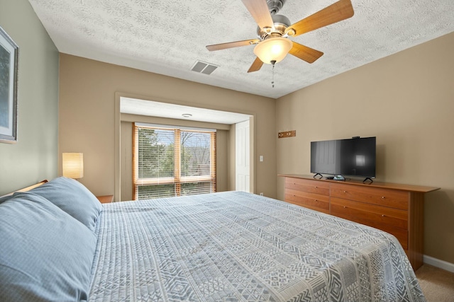 carpeted bedroom with ceiling fan, baseboards, visible vents, and a textured ceiling