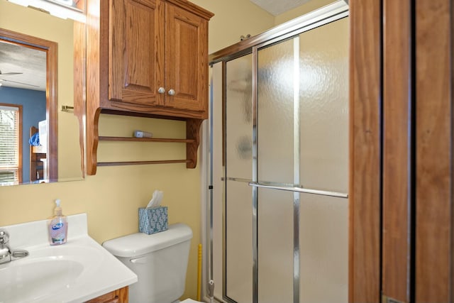 bathroom featuring a stall shower, toilet, and vanity