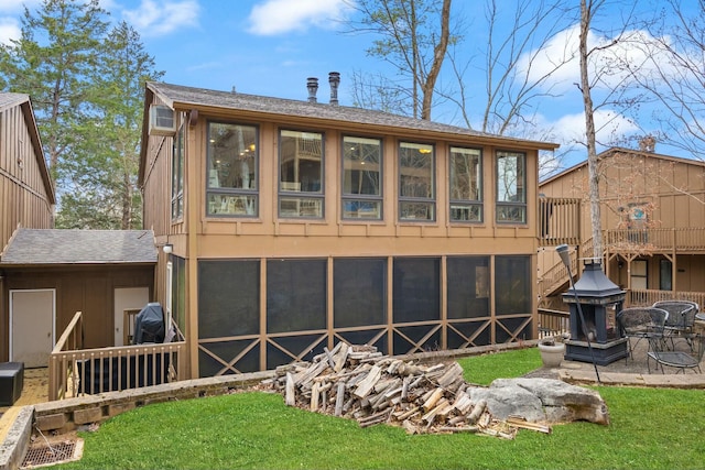 rear view of property featuring a lawn, a shingled roof, and a wall mounted AC