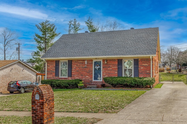 view of front facade with brick siding, driveway, a front lawn, and a gate