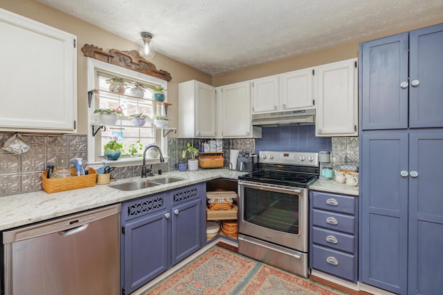 kitchen featuring under cabinet range hood, stainless steel appliances, blue cabinets, and a sink