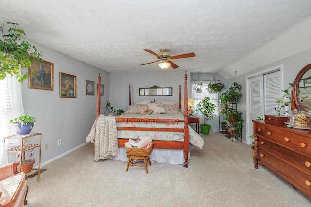 bedroom with baseboards, carpet floors, a closet, a textured ceiling, and a ceiling fan