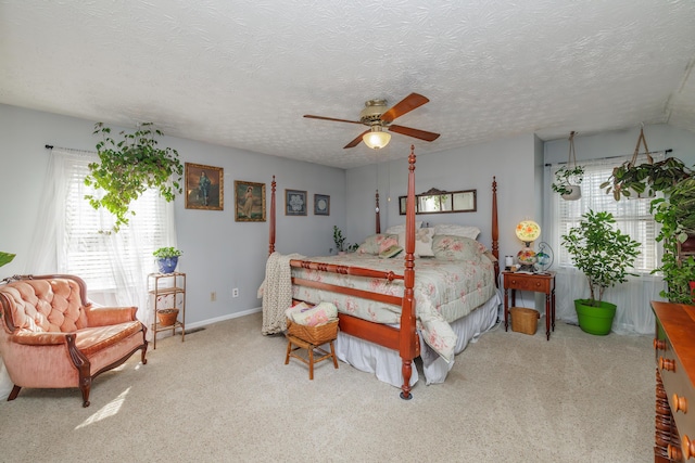 bedroom featuring baseboards, carpet floors, a textured ceiling, and a ceiling fan