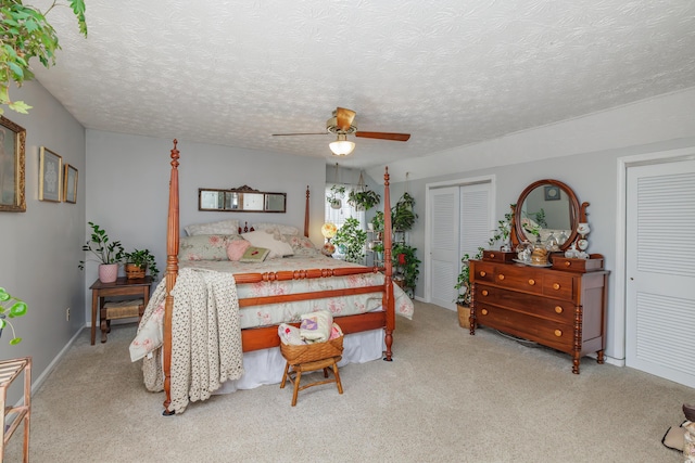 bedroom featuring light colored carpet, a textured ceiling, and ceiling fan