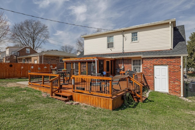 back of property featuring a yard, fence, and brick siding