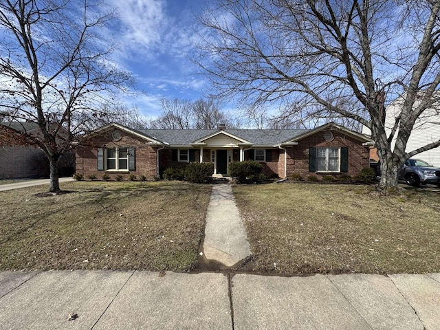 ranch-style house with brick siding, a front lawn, and a shingled roof