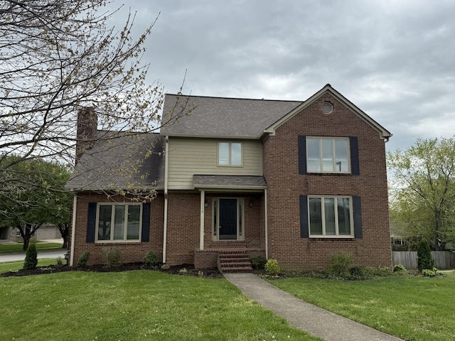 traditional home with brick siding, roof with shingles, and a front yard