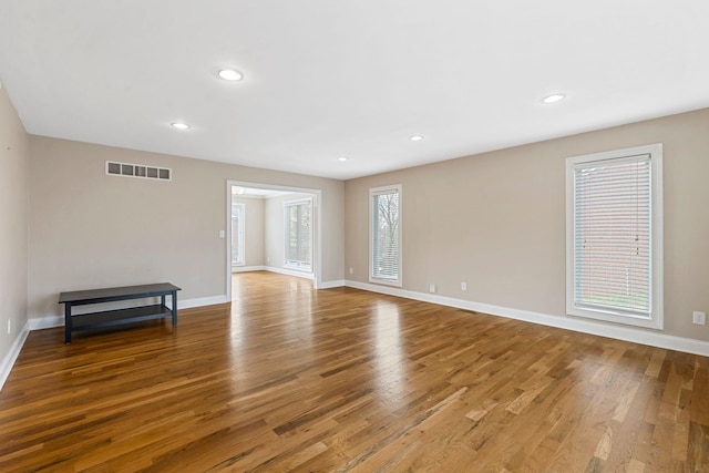 empty room featuring recessed lighting, visible vents, baseboards, and wood finished floors