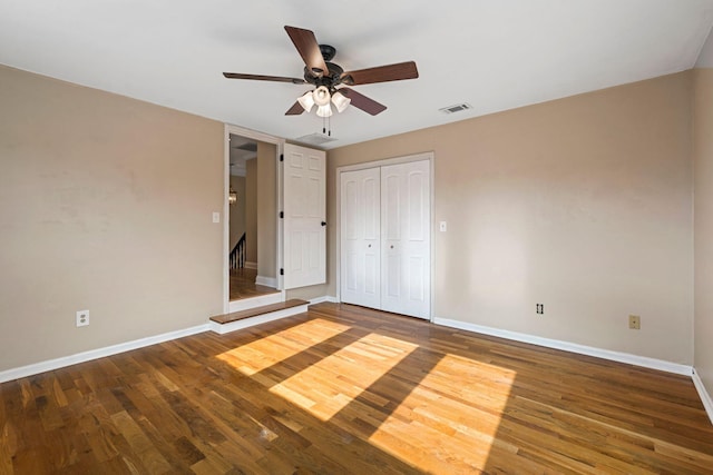 unfurnished bedroom with visible vents, baseboards, a closet, and wood finished floors