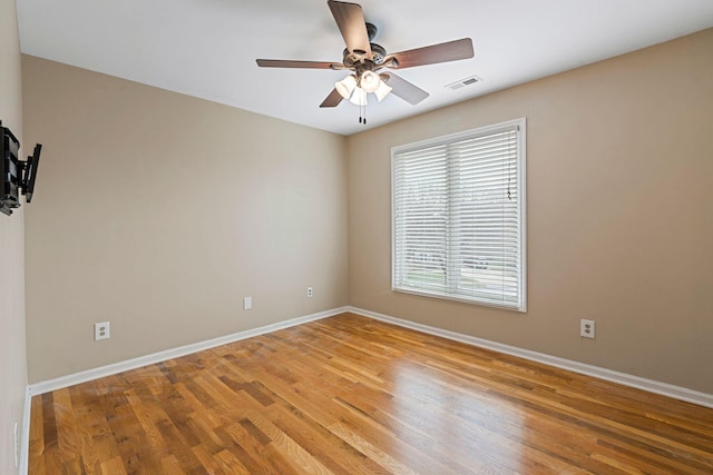 unfurnished room featuring light wood finished floors, baseboards, visible vents, and ceiling fan
