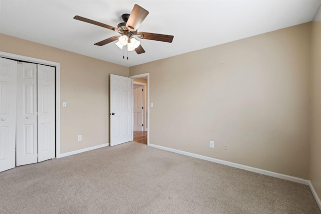 unfurnished bedroom with a ceiling fan, baseboards, a closet, and light carpet