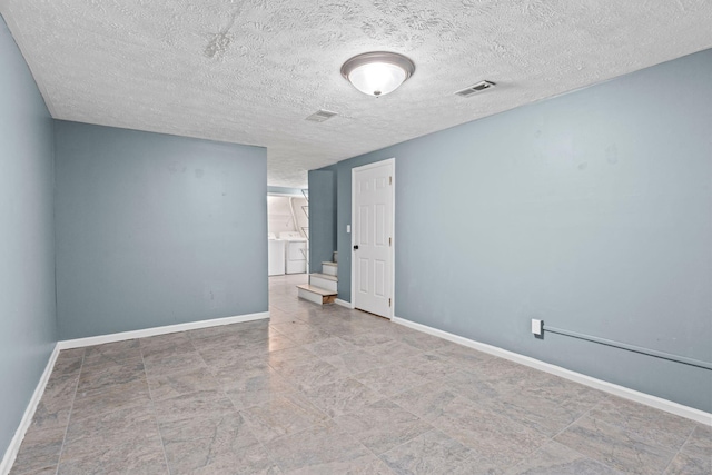 empty room with a textured ceiling, stairway, visible vents, and baseboards