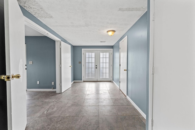 interior space with french doors, a textured ceiling, and baseboards