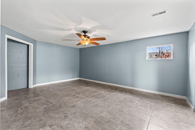 unfurnished room featuring visible vents, a ceiling fan, and baseboards