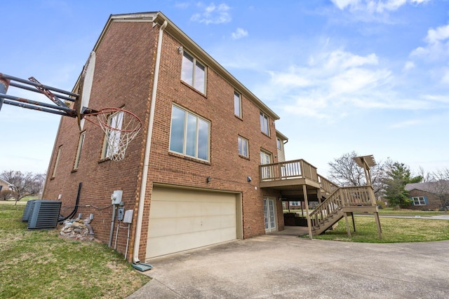 back of property featuring an attached garage, stairs, concrete driveway, central air condition unit, and brick siding