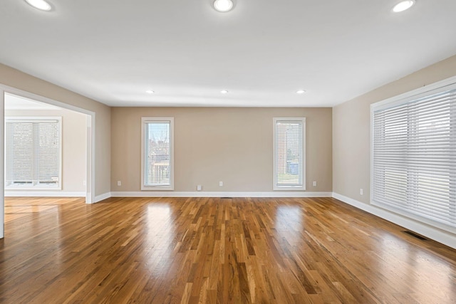 spare room featuring recessed lighting, visible vents, baseboards, and wood finished floors