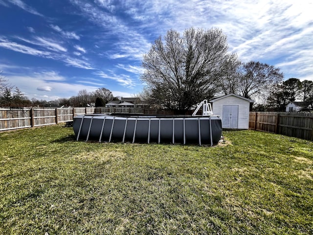 view of yard with a storage unit, an outdoor structure, a fenced in pool, and a fenced backyard