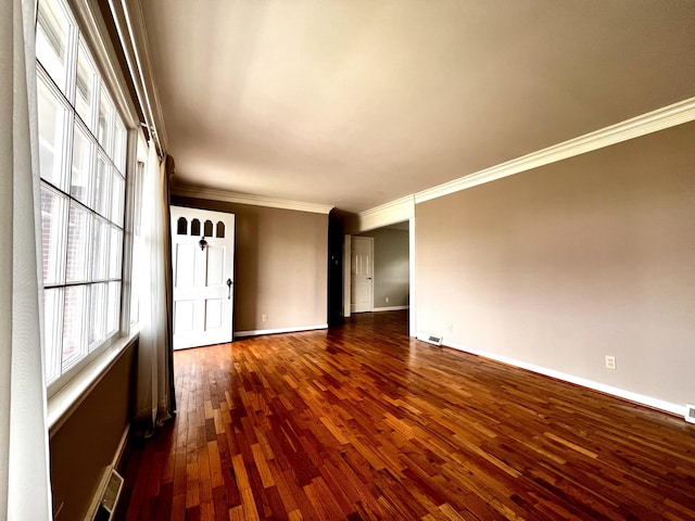 spare room featuring visible vents, crown molding, dark wood-style floors, and baseboards