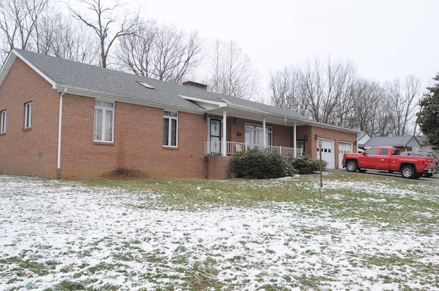 ranch-style house featuring brick siding, a chimney, an attached garage, and a shingled roof