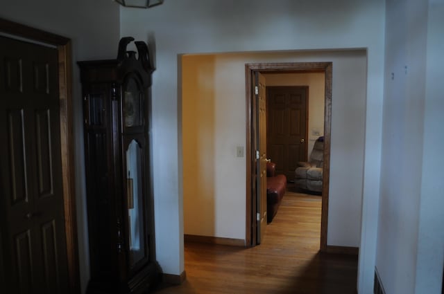 corridor with wood finished floors and baseboards