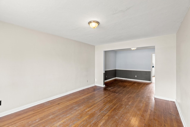 unfurnished room featuring baseboards and wood-type flooring