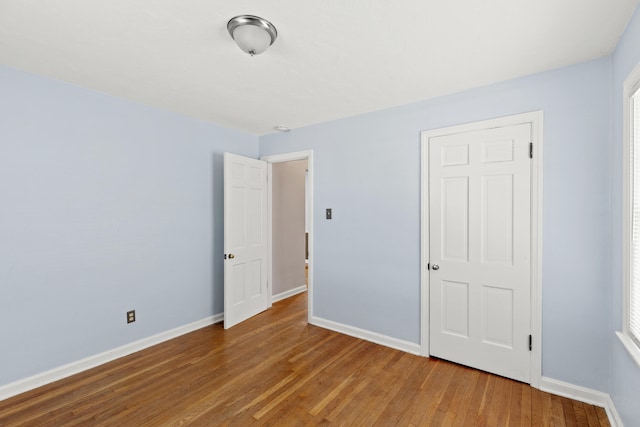 unfurnished bedroom with baseboards and wood finished floors