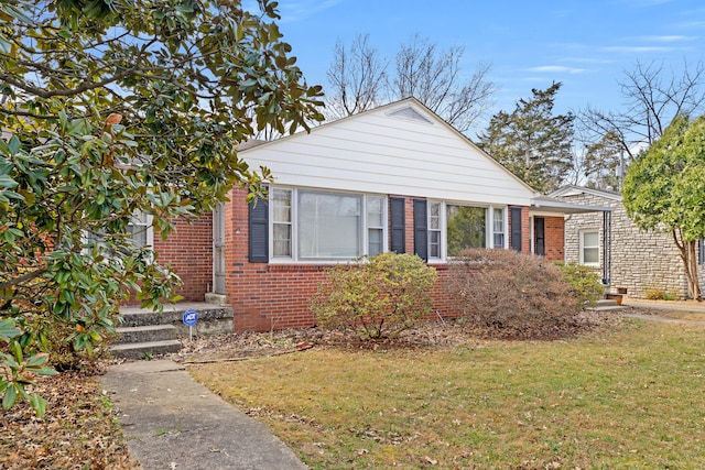 bungalow-style home with a front lawn and brick siding