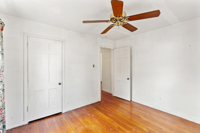 unfurnished bedroom featuring baseboards, light wood finished floors, and ceiling fan