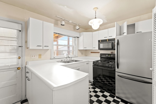 kitchen featuring black appliances, a peninsula, tile patterned floors, white cabinetry, and a sink