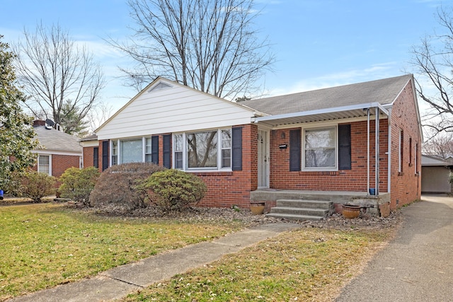 bungalow-style house featuring brick siding, driveway, and a front yard