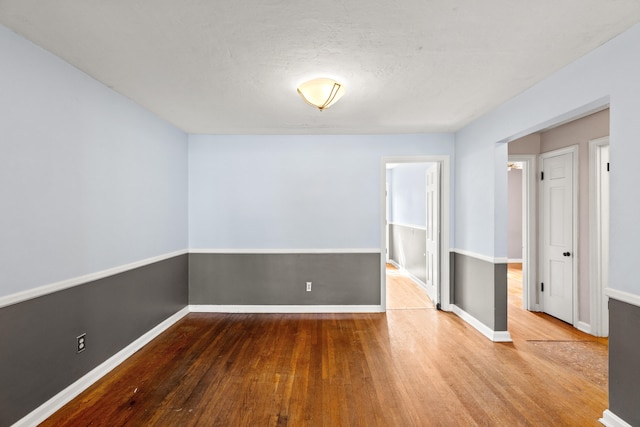 unfurnished room with wood finished floors and baseboards