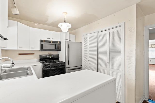 kitchen with black appliances, a sink, white cabinetry, light countertops, and hanging light fixtures