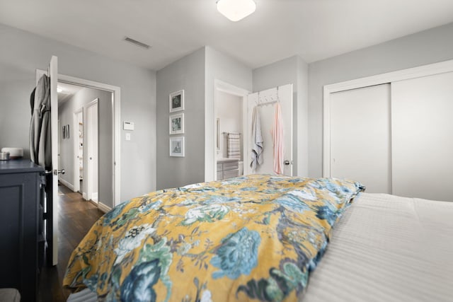 bedroom featuring a closet, visible vents, dark wood-type flooring, and baseboards