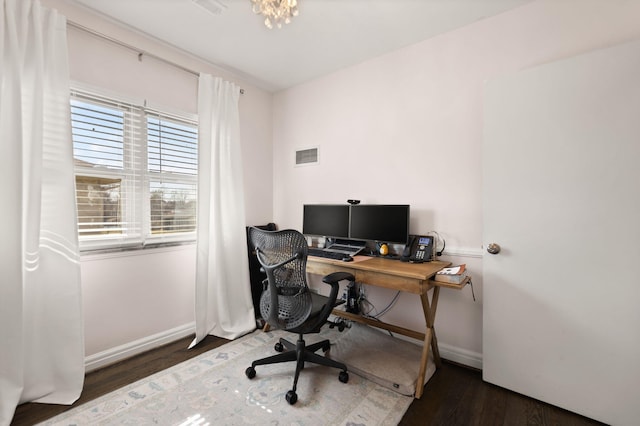 office area with visible vents, baseboards, and wood finished floors