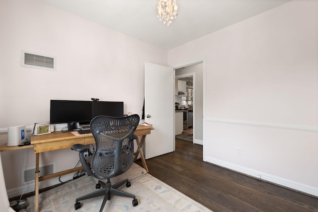 office area with a notable chandelier, wood finished floors, visible vents, and baseboards